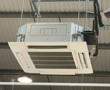 Ceiling cassette unit suspended in an open warehouse ceiling
