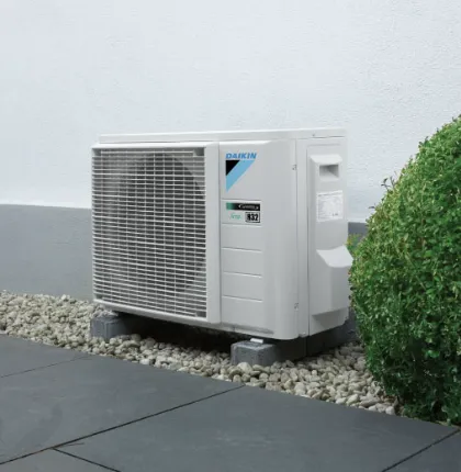 Single outdoor unit installed on a gravel bed beside a wall
